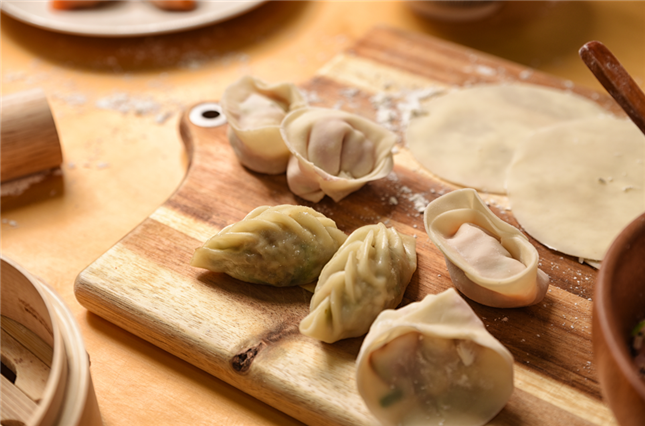 Korean dumplings are placed on a cutting board.